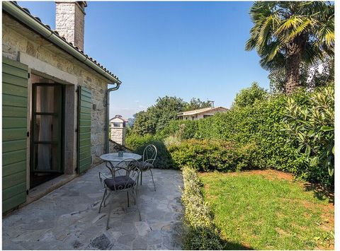 A breathtaking luxury stone villa with a beautiful pool surrounded by green.