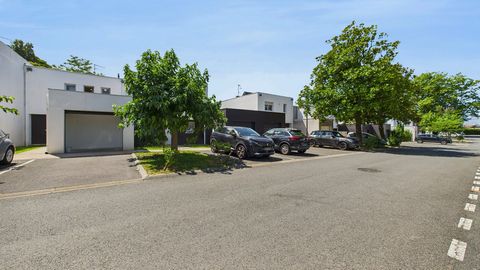 Maison moderne avec jardin et parking.