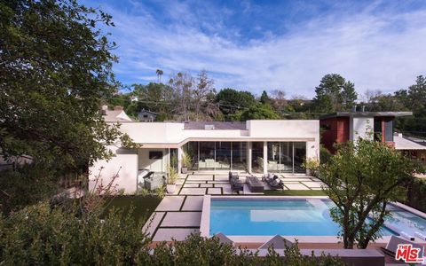 Immerse yourself in the exquisite modern architecture of this Bel Air masterpiece. With meticulous attention to detail, this home offers privacy on expansive lush grounds. Floor-to-ceiling windows, flooded with natural light, complementing the open f...