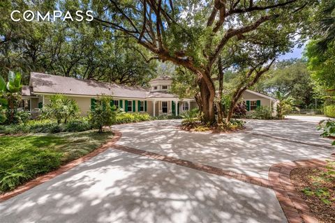 Welcome to this gorgeous Ponce Davis estate, set on over an acre of lush, curated tropical grounds beneath majestic oaks. This 4700 sf, 5bd 4ba Cape Cod-style CBS home blends old Florida charm with modern updates, including unique brick and wood acce...