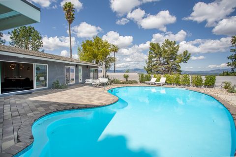 Mid-Century modernized with big views. Single-story located south of Ventura Boulevard in the hills of Tarzana. Open floor plan, walls of windows, light-filled rooms and hardwood floors throughout, 4 en-suite bedrooms including a chic primary suite w...