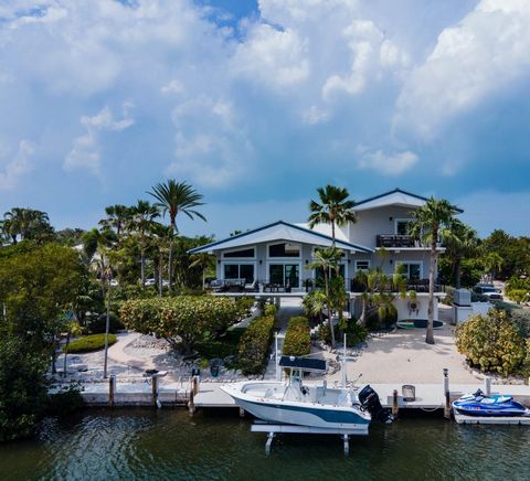 Discover the refined elegance of this beautifully appointed home located on a canal front in Stirrup Key. Every aspect of this residence reflects high-end finishes, executed with tasteful sophistication. The kitchen boasts granite countertops and sta...